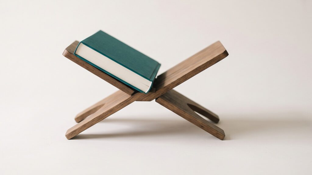 A teal book resting open on a folding wooden book stand