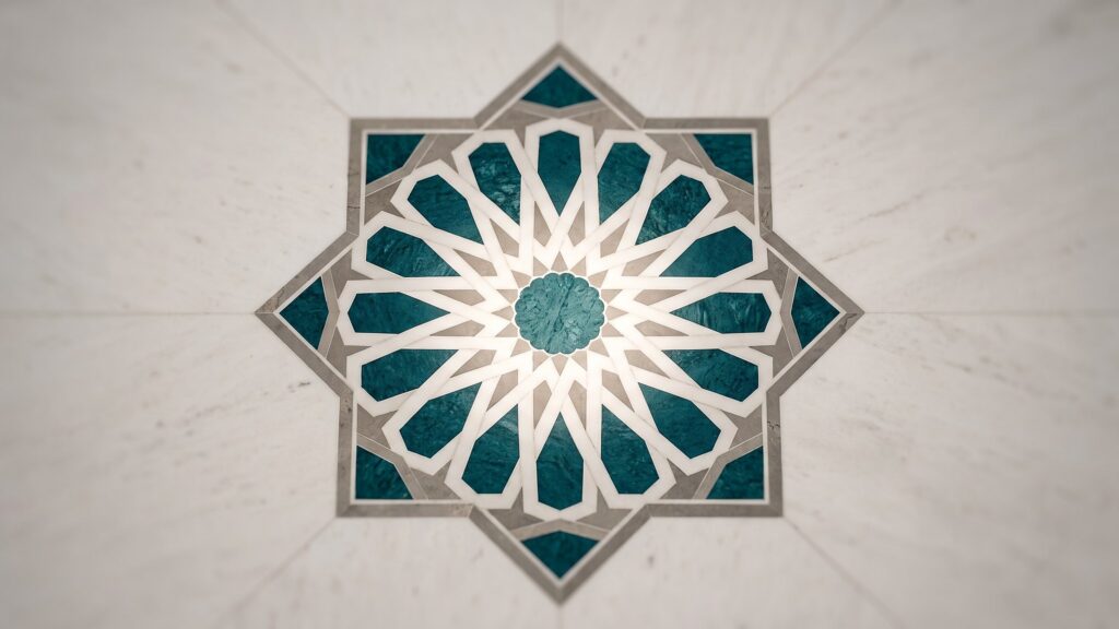 An eight pointed star tile medallion in teal and white set into a plaster wall
