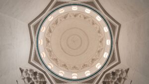 The interior of a mosque dome with concentric plaster mouldings and small windows
